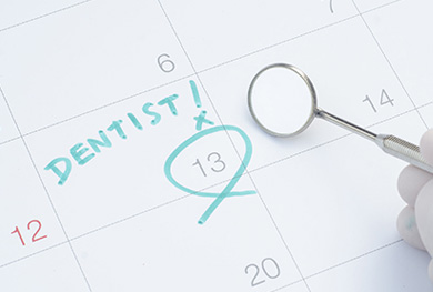 The image shows a calendar with the word dentist circled and marked with an exclamation mark, accompanied by a magnifying glass, suggesting a focus on dental health appointments.